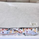 Funda de tela ecológica con estampado colorido en la parte inferior, presentada en un empaque transparente. Ideal para organizar y proteger objetos. Precio de $24.95.