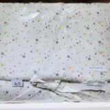 Funda de tela con estampado de estrellas en colores rosa, amarillo y negro, ideal para decoración de habitaciones infantiles, precio de $24.95.