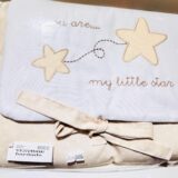 Manta bordada para bebés con diseño de estrellas y texto "my little star", en tonos suaves y con un lazo decorativo. Ideal para decoración de habitaciones infantiles.